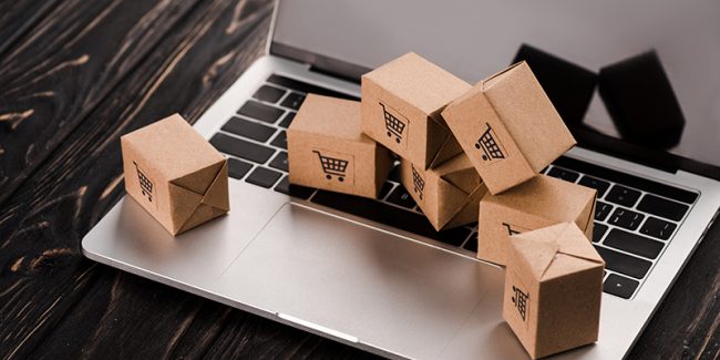 small carton boxes on laptop with blank screen, e-commerce conce