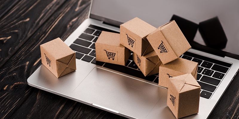 small carton boxes on laptop with blank screen, e-commerce conce